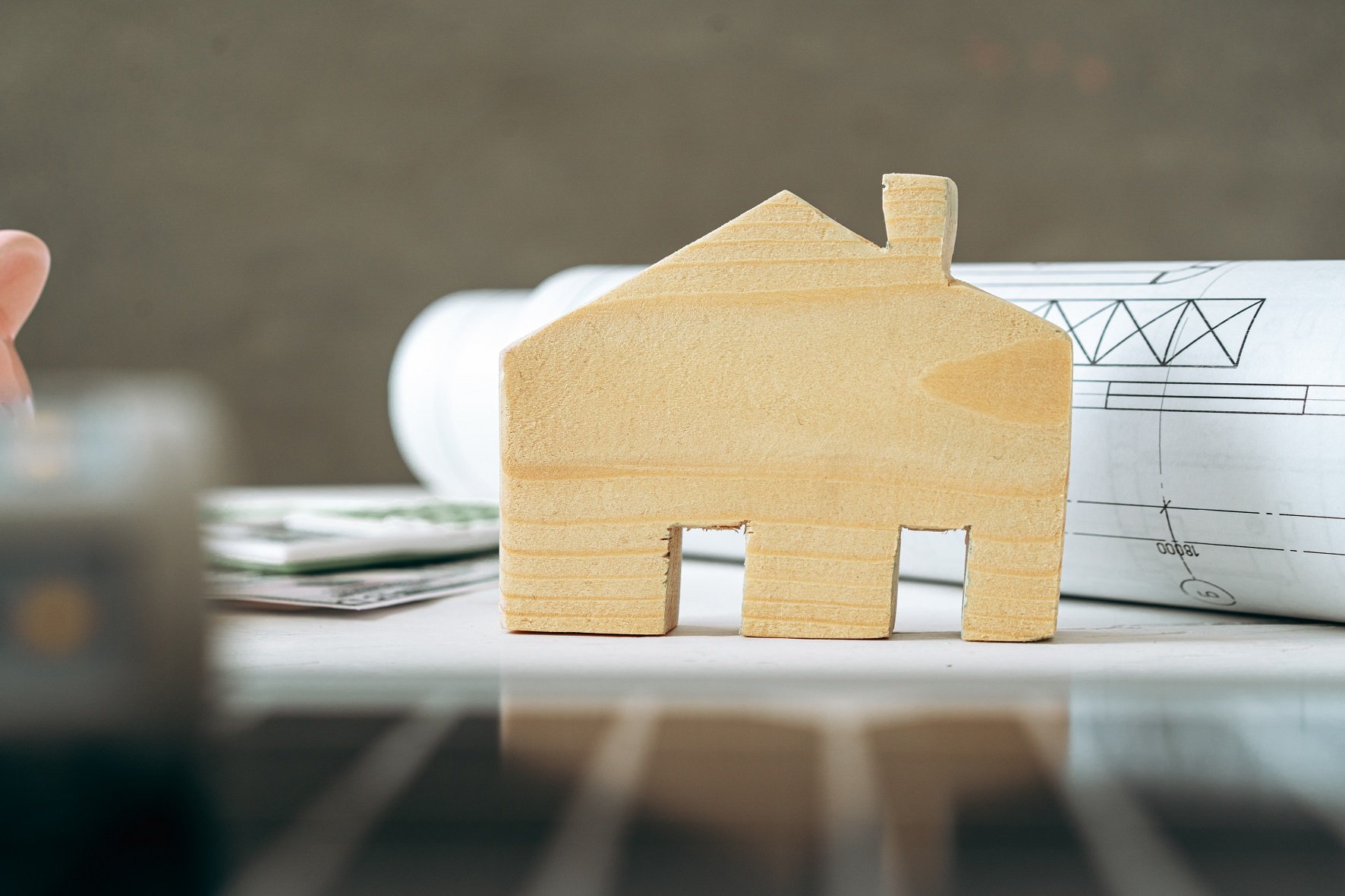 wooden-house-miniature-and-blueprints-on-wooden-table